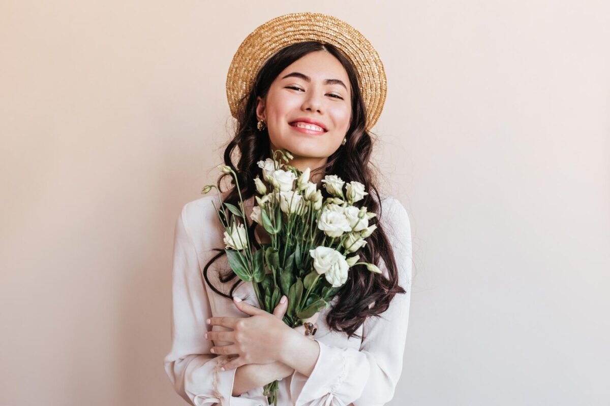 cheerful-asian-girl-straw-hat-holding-flowers-young-woman-with-white-eustomas-expressing-happiness_197531-26742