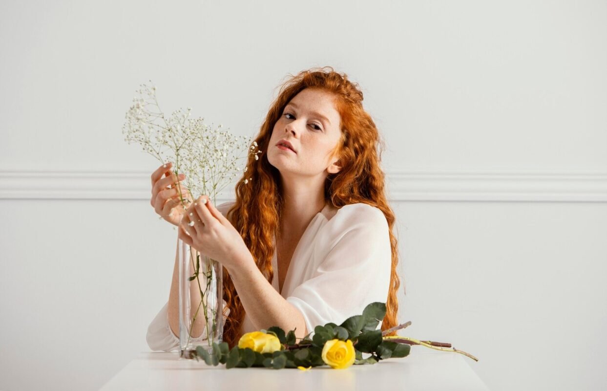 front-view-beautiful-woman-posing-with-spring-flowers-table_23-2148853898